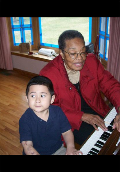 Piano lessons from great Aunt Emily! Is he paying attention? Looks like he is really interested!?