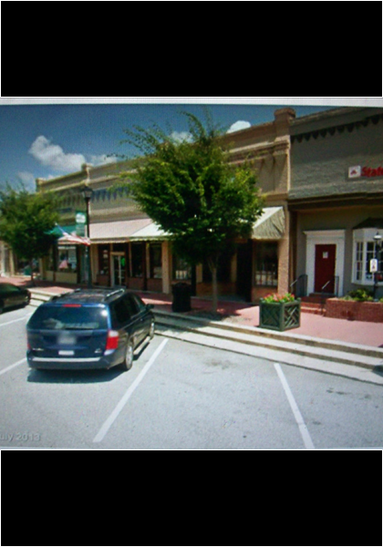The cafe is to the left of state farm, notice the streetlamps!